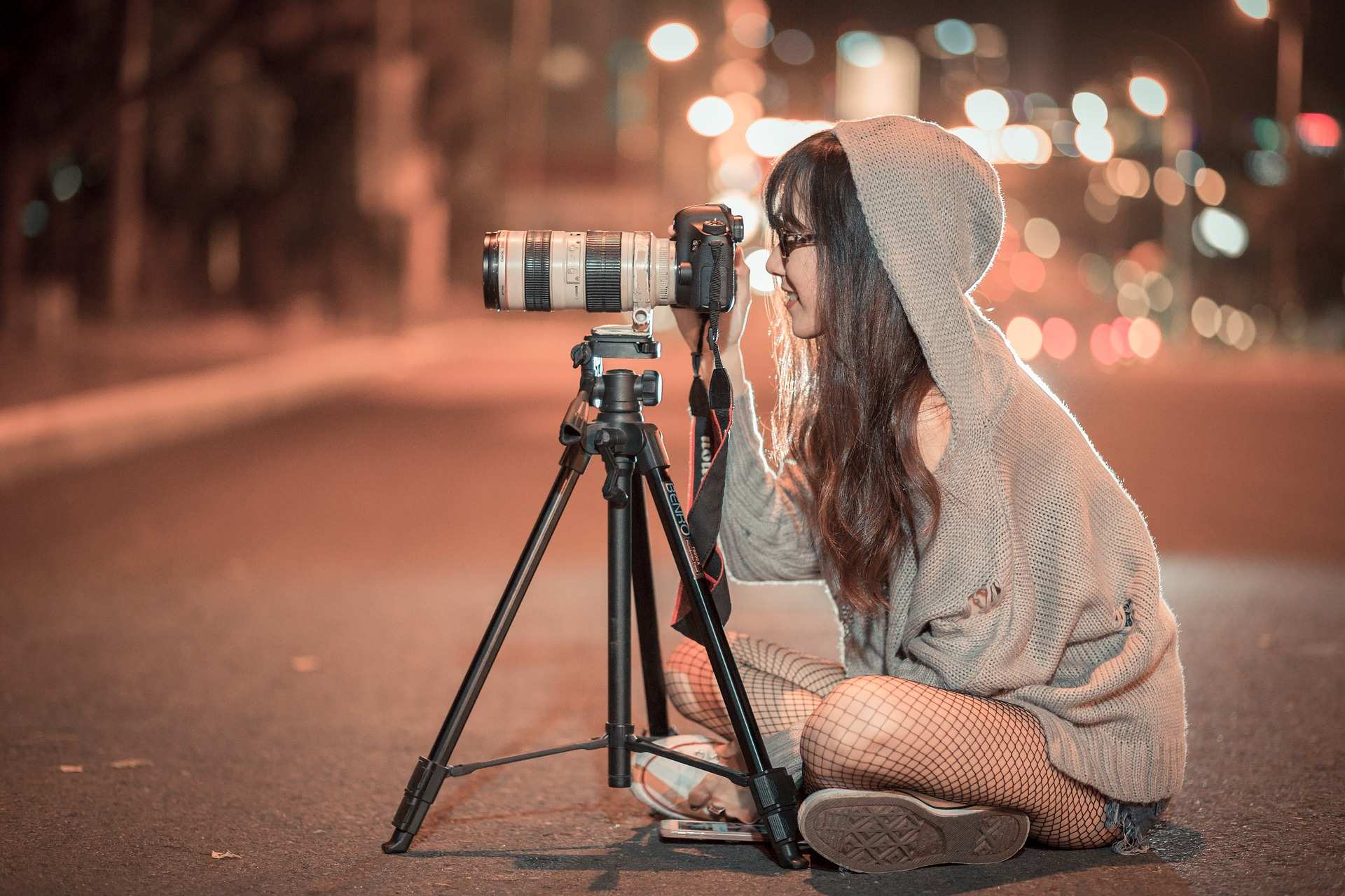 Eine Fotografin sitzt vor ihrer Kamera